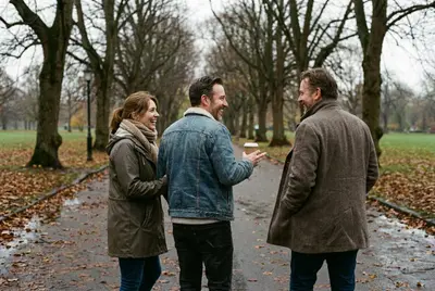Three friends talking and laughing on a leaf-covered park path